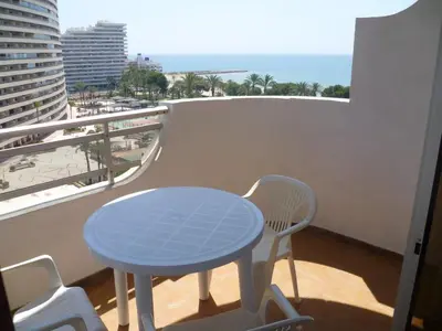 a blue table and chairs on a balcony with the ocean at Las Vegas, Esc-3, 7º-19 in Cullera