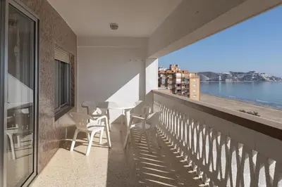 a balcony with a table and chairs and a view of the ocean at Lider, 10-B in Cullera
