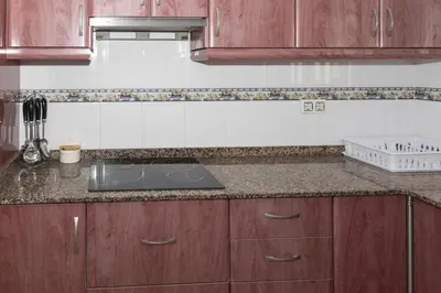 a kitchen with wooden cabinets and a sink at Lider, 10-B in Cullera