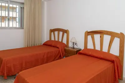 two beds in a room with orange sheets at Lider, 10-B in Cullera