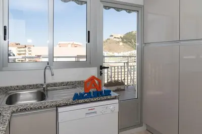 a kitchen with a sink and a view of the ocean at LIDER, 12º-A Atico in Cullera