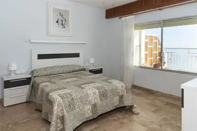 a bedroom with a bed and a large window at LIDER, 12º-A Atico in Cullera