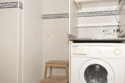 a laundry room with a washing machine and a stool at Lider, 44-E (Planta Baja) in Cullera