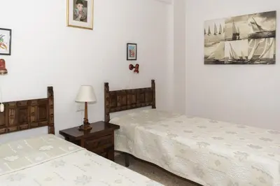 a bedroom with two beds and a table with a lamp at Lider, 4-D in Cullera