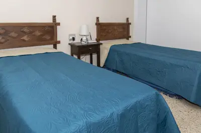 a hotel room with two beds and a table with a lamp at Lider, 5-B in Cullera