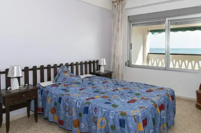 a bedroom with a bed with a blue comforter and a window at Lider, 5-B in Cullera