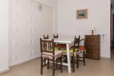 a dining room table with four chairs and a dresser at Lider, 5-B in Cullera