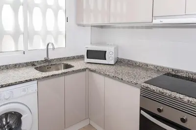 a white kitchen with a sink and a microwave at Lider, 8-A in Cullera