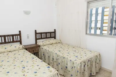 a bedroom with two beds and a window at Lider, 8-A in Cullera