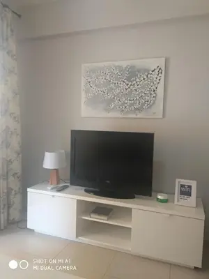 a flat screen tv sitting on top of a white entertainment center at Mar Y Montaña 7º-119 in Cullera