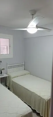 a bedroom with two beds and a ceiling fan at Mar Y Montaña 7º-119 in Cullera
