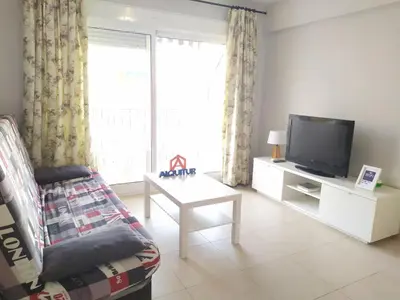 a living room with a tv and a couch and a table at Mar Y Montaña 7º-119 in Cullera
