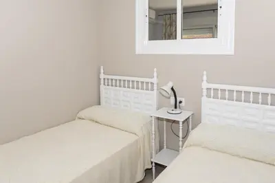 two beds in a room with a mirror and a table at Mar Y Montaña 7º-119 in Cullera