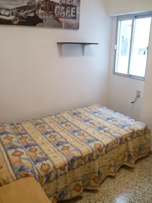 a bed in a room with a quilt on it at Miralmar, 10º-69 in Cullera