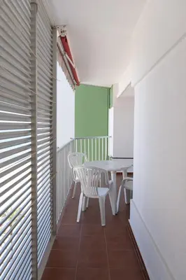 a room with a table and chairs on a balcony at Montemar, B-9º-26 in Cullera