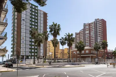 an empty parking lot with palm trees and buildings at Montemar, B-9º-26 in Cullera