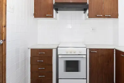 a kitchen with a white stove and wooden cabinets at Montemar, C-12º-33 in Cullera