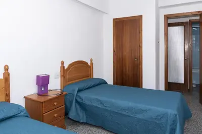 a bedroom with two beds and a dresser with a purple box at Montemar, C-12º-33 in Cullera