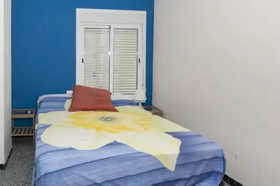 a blue bedroom with a bed with a flower on it at Montemar, C-8º-22 in Cullera