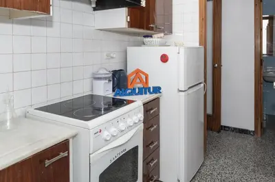a kitchen with a white stove top oven next to a refrigerator at Montemar, C-8º-22 in Cullera