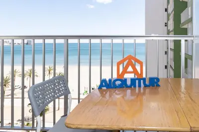 a wooden table on a balcony with a view of the beach at Montemar, C-8º-22 in Cullera