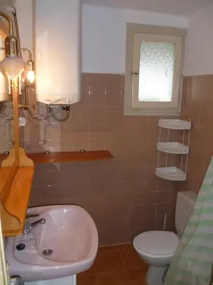 a bathroom with a sink and a toilet and a window at Nautic, 7º-O in Cullera