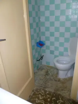 a bathroom with a toilet in a blue and green tiles at Nautic, 7º-O in Cullera