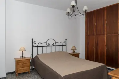 a bedroom with a bed and a dresser and cabinets at Nautilo, 8º-15 in Cullera
