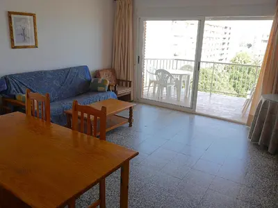 a living room with a couch and a table and a patio at Nautilo, 8º-15 in Cullera