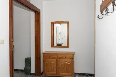 a hallway with a mirror and a wooden dresser at Nautilo, 8º-15 in Cullera