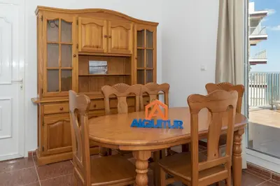 a dining room with a wooden table and chairs at Pleno Sol, 45 in Cullera