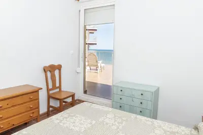 a bedroom with a bed and a chair and a window at Pleno Sol, 45 in Cullera