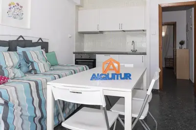 a kitchen and a living room with a table and a couch at Prado, B-6º-64 in Cullera