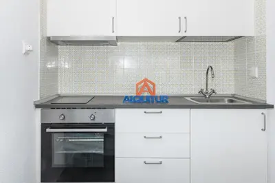 a kitchen with white cabinets and a sink at Prado, B-6º-64 in Cullera