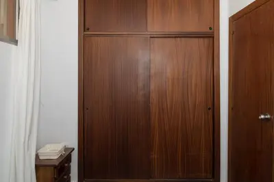 a wooden cabinet in a room with a desk at Prado, B-6º-64 in Cullera