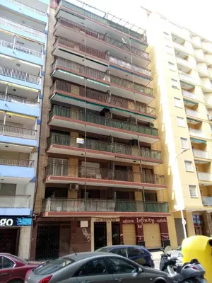 a tall building with cars parked in front of it at Provence, 5º-18 in Cullera