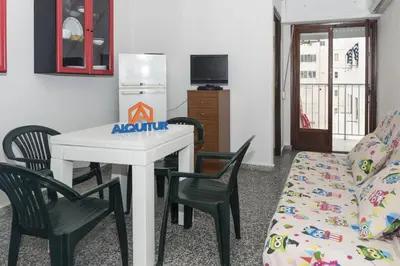 a living room with a table and chairs and a couch at Provence, 7º-25 in Cullera