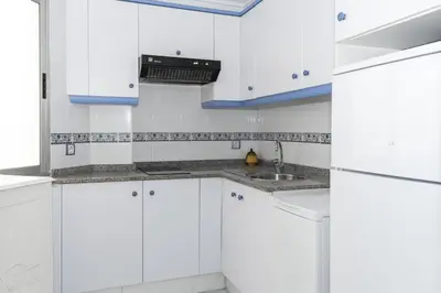 a white kitchen with white cabinets and a sink at Saint Germain 7/B1, 8º-16 in Cullera