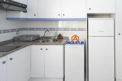 a kitchen with white cabinets and a refrigerator at Saint Germain 7/B1, 8º-16 in Cullera