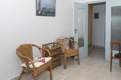 a room with wicker chairs and a dresser and a mirror at Santa Marta, I-A 7º-19 in Cullera