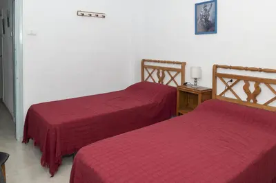 two beds in a room with red sheets on them at Santa Marta, I-A 7º-19 in Cullera