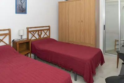 a room with two beds with red sheets in it at Santa Marta, I-A 7º-19 in Cullera