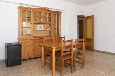 a dining room with a wooden table and chairs at Santa Marta, Iii-A 7º-16 in Cullera
