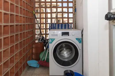 a washing machine in a corner of a room at Santa Marta, Iii-A 7º-16 in Cullera