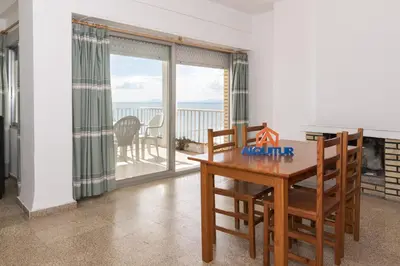 a dining room with a table and a view of the ocean at Santa Marta, Iii-A 7º-16 in Cullera