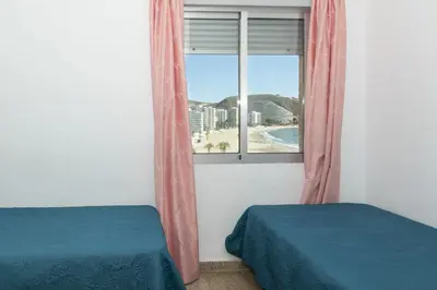 a bedroom with a window with a view of the beach at Santa Marta, Iii-A 7º-16 in Cullera