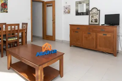 a living room with a table and a dining room at Seniades, 6º-16 in Cullera
