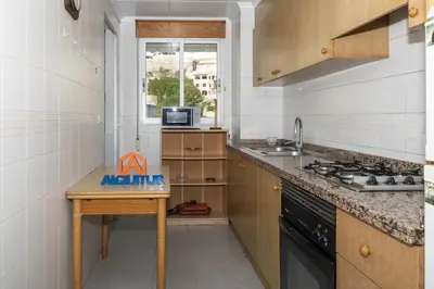 a kitchen with a table and a sink and a stove at Seniades, 6º-16 in Cullera