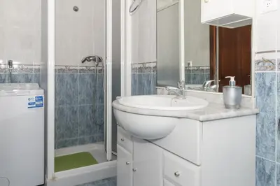 a white bathroom with a sink and a shower at Trianon, 5º-29 in Cullera