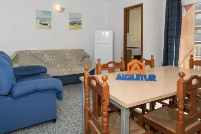 a living room with a table and a blue couch at Trianon, 5º-29 in Cullera